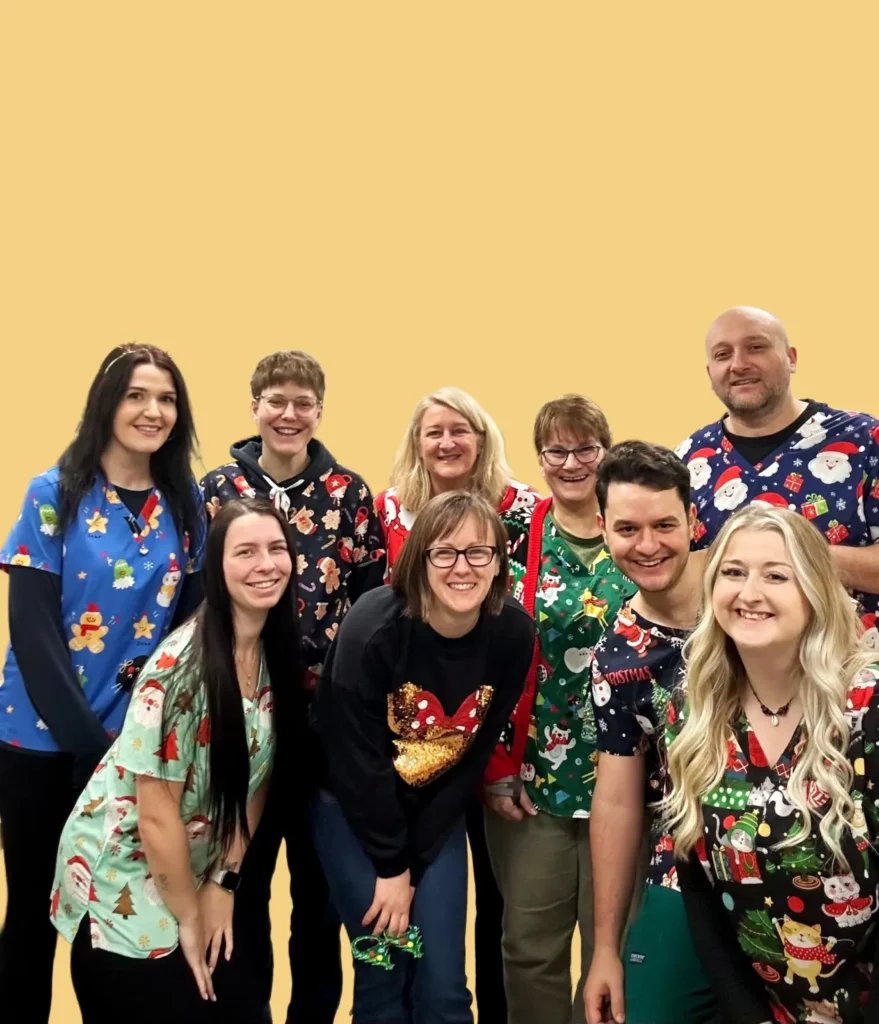 Group wearing festive holiday shirts.About us